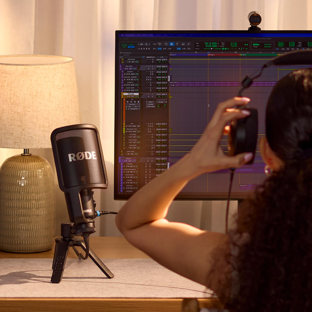 RØDE NT-USB+ on a desk with headphones and a music production setup